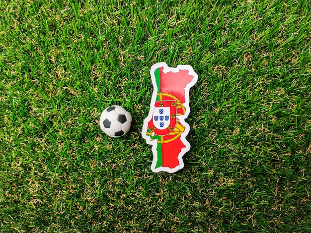 Naklejka z piłką i flagą Portugalii znajduje się na zielonym polu
