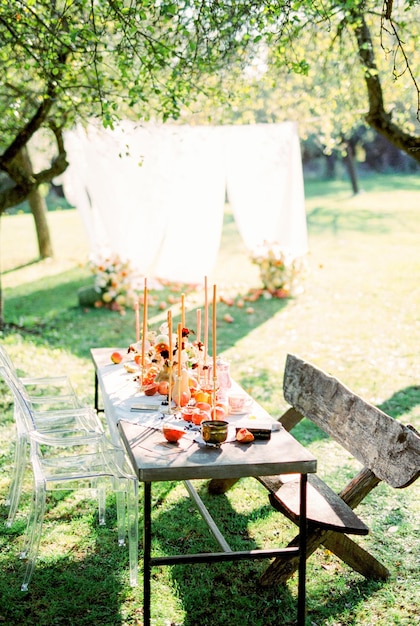 Nakryty stół ze świecami w zielonym ogrodzie