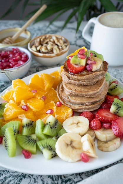 Zdjęcie naleśniki ze świeżymi owocami. sałatka owocowa z naleśnikami bezglutenowymi. zdrowe śniadanie pełne witamin