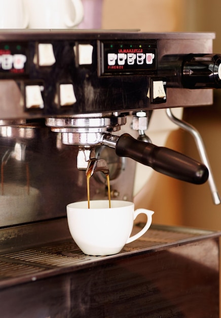 Nalewanie kubka do kawy i maszyny w kawiarni na napój espresso latte lub gorący napój Urządzenie elektryczne w restauracji i kubek z kofeiną do robienia lub parzenia cappuccino w sklepie detalicznym lub małej firmie