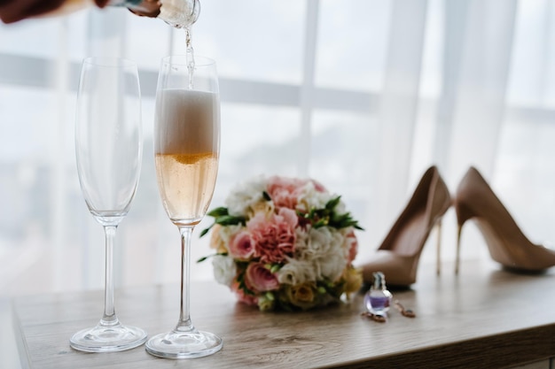 Nalewanie szampana w kieliszkach stojących na stole Dzień ślubu
