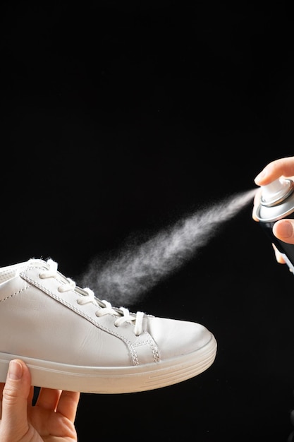 Nałożenie wodoodpornego sprayu hydrofobowego na białe tenisówki damskie Ochrona obuwia przed wilgocią, brudem i nieprzyjemnym zapachem