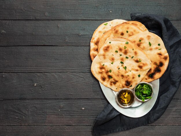 Zdjęcie nan flatbreads na ciemnym drewnie kopiować przestrzeń widok z góry