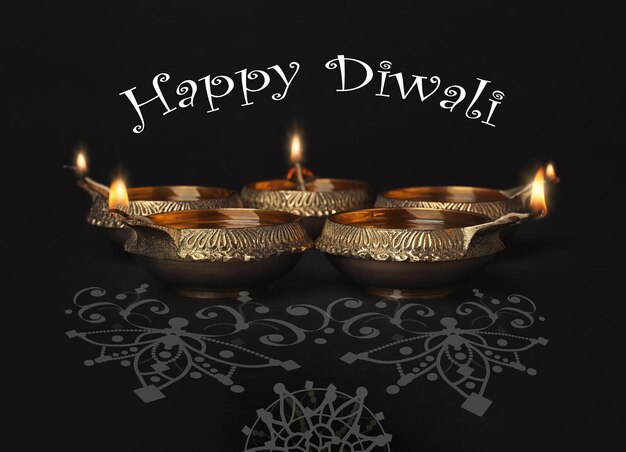 Napis Happy Diwali i gliniane lampy na ciemnym tle