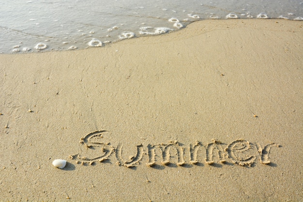 napis „lato” na piasku na brzegu morza