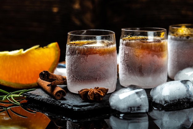 Zdjęcie napój alkoholowy i pomarańcza w szklankach lodu alkoholowy koktajl alkoholowy niemiecki digestif z 56 ziół i przypraw