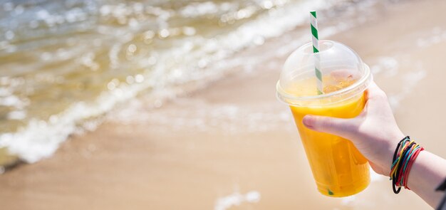 Napój lodowy sok żółty lemoniada na plaży brzeg morza pomarańczowy świeży orzeźwiający napój relaks