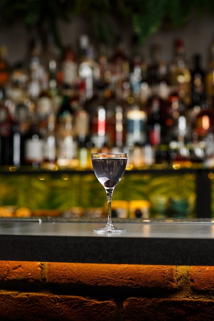 Napój lotniczy z sokiem z cytryny gin z likierem maraschino i likierem fiołkowym stojącym na blacie barowym