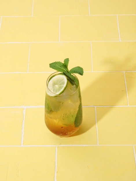 Napój Mojito lub virgin mojito long rum z sokiem ze świeżej mięty z limonki, cukrem trzcinowym i sodą Na żółtym tle