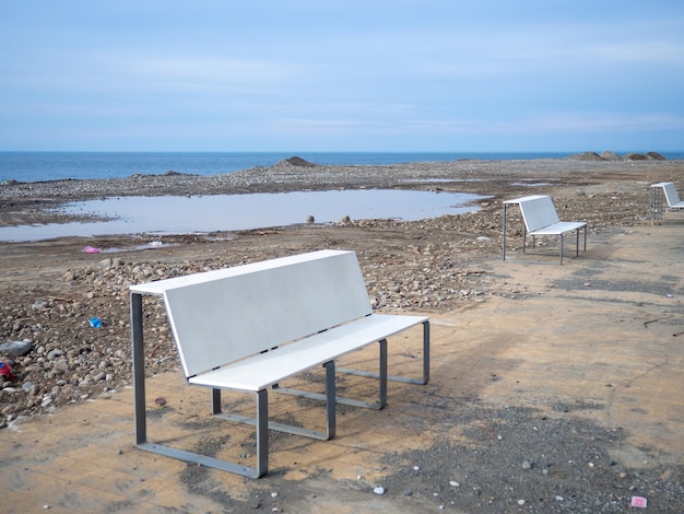 Zdjęcie naprawa nabrzeża nadmorskiego kurortu przygotowanie do sezonu turystycznego zrównanie gruntu na plaży prace remontowe ławki stołowe na plaży
