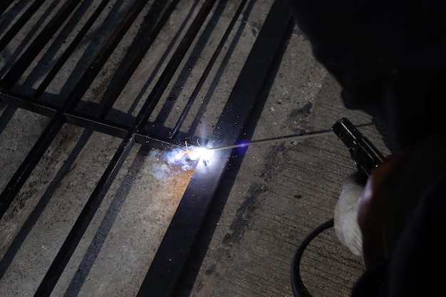 Zdjęcie naprawa żelaznej bramy, ręczne spawanie stali dla pracowników