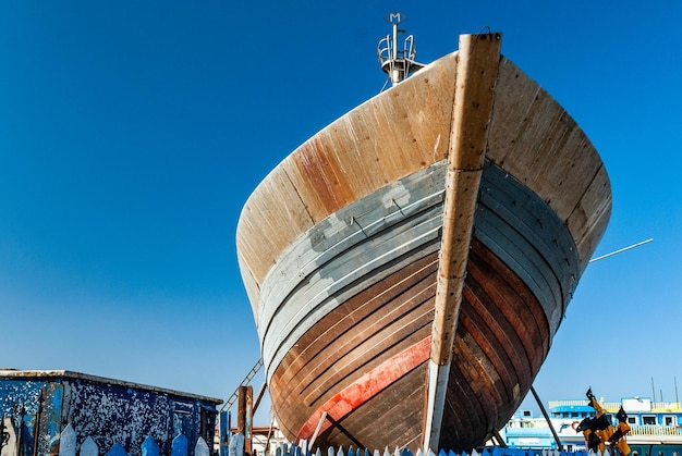 Naprawy na dziobie łodzi rybackiej w suchym doku w porcie Essaouira w Maroku