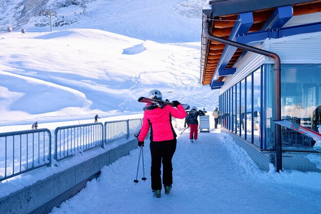 Narciarz z nartami do stacji kolejki linowej na lodowcu Hintertux w Tyrolu w Mayrhofen w Austrii, Alpy zimą. Lady girl w budynku biletowym w Hintertuxer Gletscher w górach alpejskich