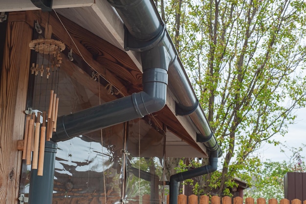 Zdjęcie narożnik domu z nowym dachem pokrytym szarą blachodachówką i rynną deszczową metalowy system rynnowy zewnętrzny system rynnowy i drenażowy