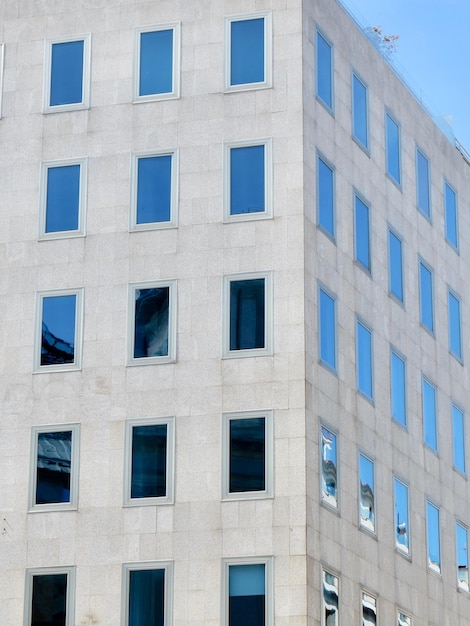 Narożnik minimalnej elewacji budynku z prostymi szklanymi oknami Pionowe zdjęcie