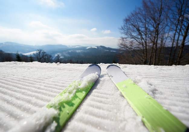 Narty na białym śnieżnym torze narciarskim zimowy górski krajobraz i błękitne niebo kopia tło miejsca