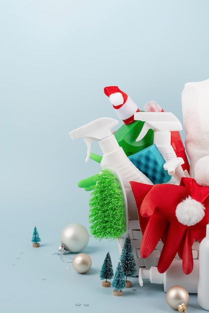 Narzędzia do czyszczenia i ozdoby świąteczne w białym koszu na bieliznę na niebieskim tle z miejscem na kopię