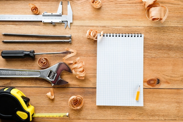 Zdjęcie narzędzia pracy i notatnik na drewnianym stole