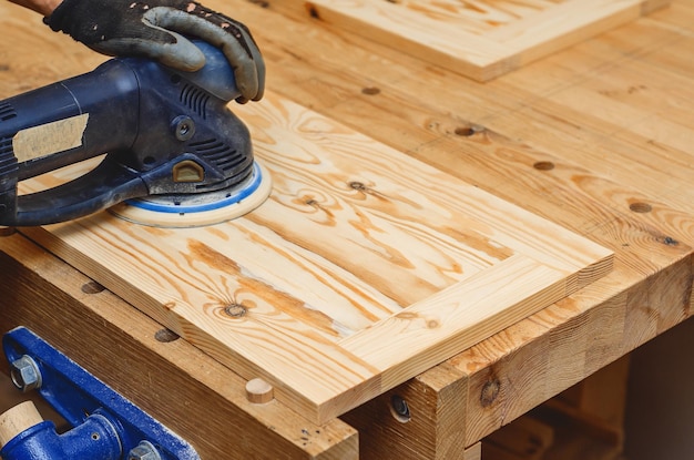 Narzędzia stolarskie Szlifowanie drewnianej deski ręczną szlifierką elektryczną