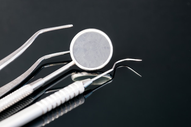 Narzędzia stomatologiczne dla dentysty w biurze lub przychodni. Na czarnym tle.