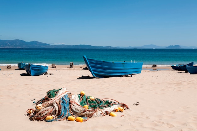 Narzędzia współpracy i łodzie rybackie na piasku plaży