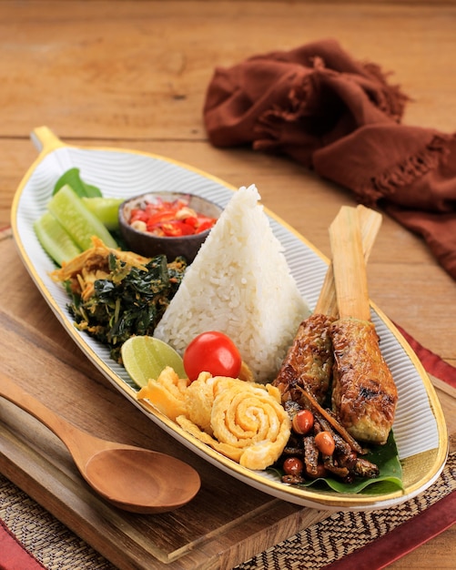 Nasi Lemak Lub Nasi Campur, Indonezyjski Ryż Balijski Z Plackiem Ziemniaczanym, Sate Lilit, Smażonym Tofu, Jajkami I Orzeszkami Ziemnymi