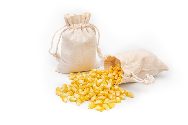 Nasiona kukurydzy w lnianej torbie na białym tle.