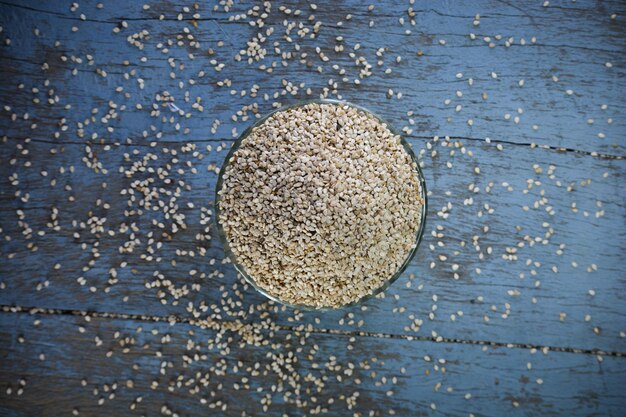 Zdjęcie nasiona sezamu w szklanej misce na drewnianym tle