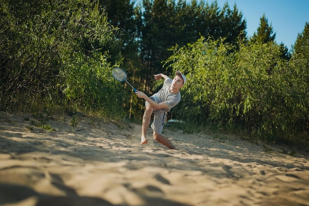 Nastolatek chłopiec gra w badmintona na plaży Obraz z selektywnym skupieniem