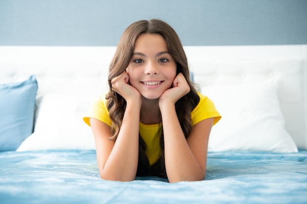 Nastolatek dziewczynka odpoczywa w łóżku w sypialni w domu Dziecko relaksuje się we wnętrzu sypialni Dziecko śni na jawie