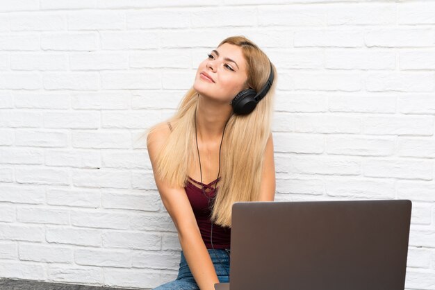 Nastolatek Dziewczyny Obsiadanie Na Podłoga Z Jej Laptopu Słuchającą Muzyką