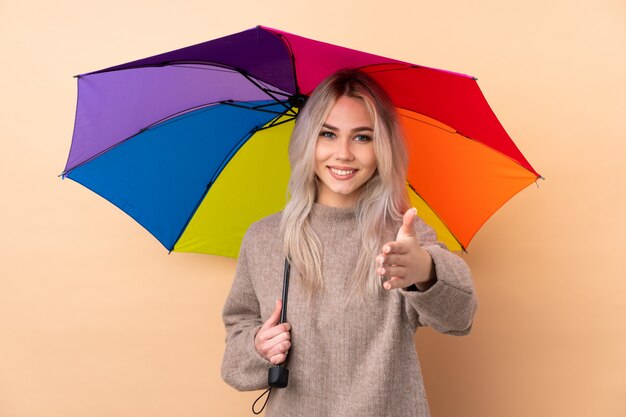 Nastolatek kobieta trzyma parasol nad odosobnionym ściennym handshaking po dobrej oferty