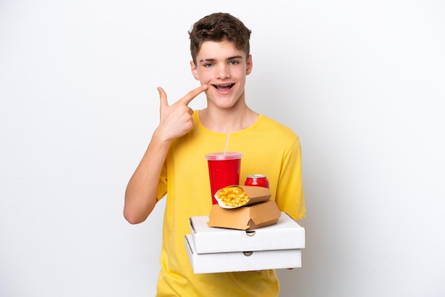 Nastolatek Rosjanin trzymający fast food na białym tle dający gest kciuka w górę