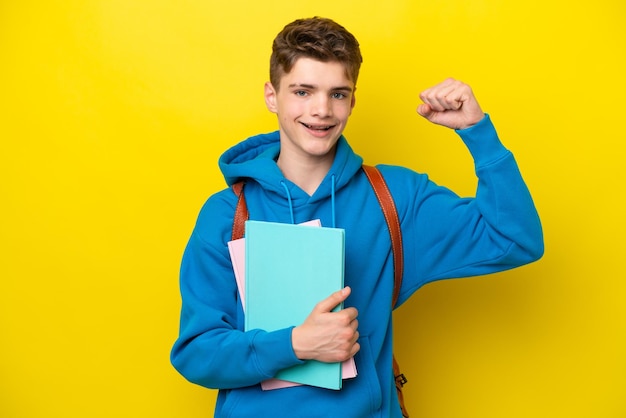 Nastolatek rosyjski student mężczyzna na żółtym tle świętuje zwycięstwo