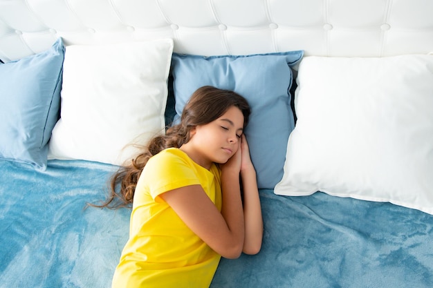Nastolatek śpi w łóżku na poduszkach w domu Dziecko leży i śpi na łóżku Dziecko nastolatka śpi w łóżku
