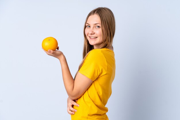 Nastolatek Ukraińska dziewczyna odizolowywająca na błękicie trzyma pomarańcze