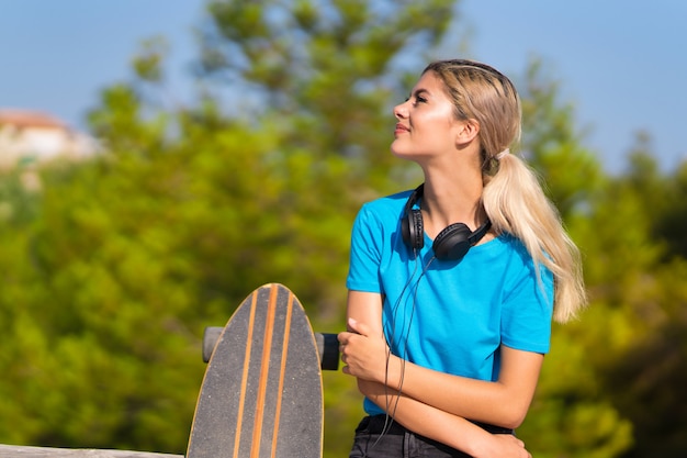 Nastolatek z skate na zewnątrz szczęśliwy i uśmiechnięty