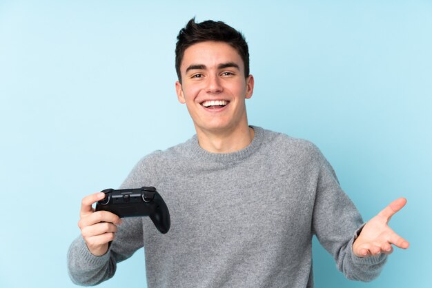 Nastolatka caucasian mężczyzna bawić się z wideo gry kontrolerem odizolowywającym na błękicie