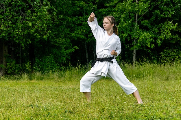 Nastolatka ćwicząca karate kata na świeżym powietrzu, wykonuje wiek-uke (blok wznoszący lub w górę)