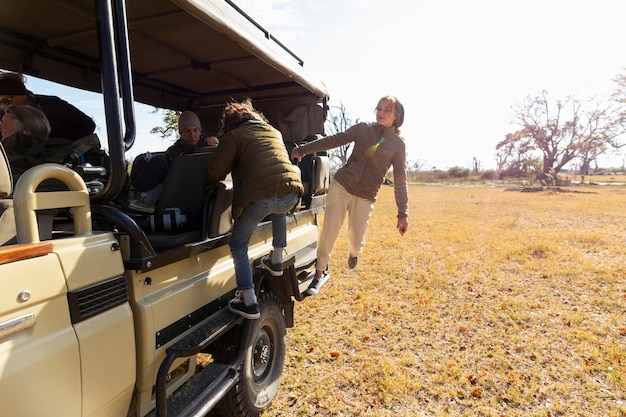 Zdjęcie nastolatka i młody chłopak wsiadają do jeepa safari