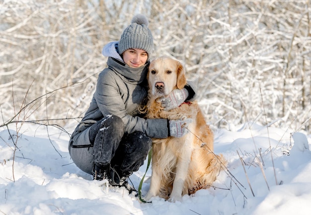 Nastolatka i złoty retriever w zimowym lesie