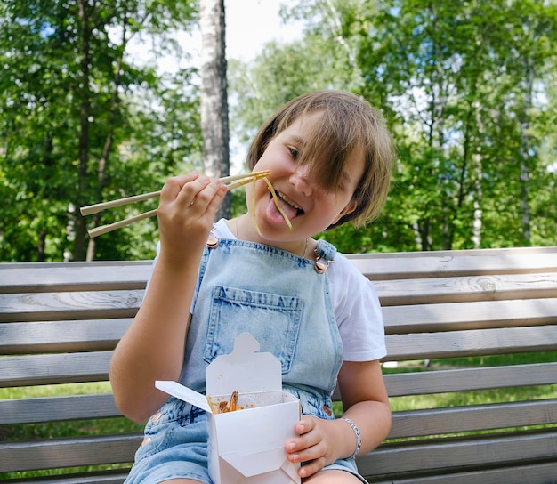 Nastolatka Na Spacerze W Letni Dzień W Parku Je Lunch Z Wokiem Z Makaronem