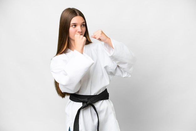 Nastolatka nad odizolowanym białym tłem robi karate
