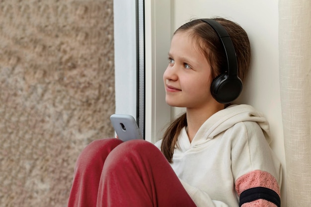 Nastolatka odpoczywa Dziewczyna ze słuchawkami smartphone słuchaj muzyki audiobook Online Nastolatka z gadżetami