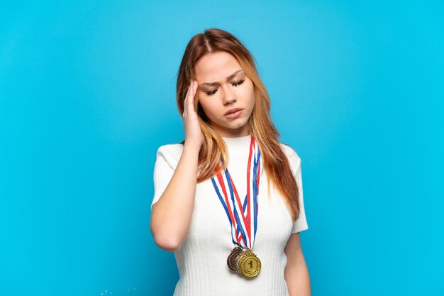 Nastolatka z medalami na białym tle z bólem głowy