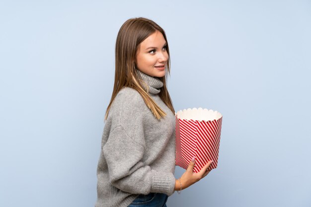 Nastolatka z sweter gospodarstwa miskę popcorns