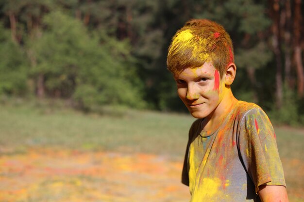 Nastoletni Chłopak W Holi Maluje. Portret Chłopca Na Festiwalu Kolorów Holi