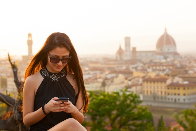 Nastoletni przy zmierzchem w Florencja używa smartphone