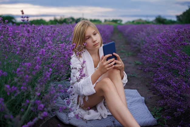 Nastoletnia dziewczyna cieszy się lawendowym polem i robi zdjęcie smartfonem letnie wakacje