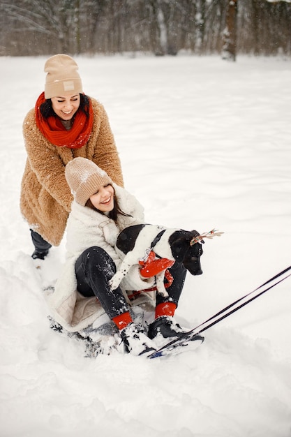 Nastoletnia dziewczyna i jej matka jeżdżą na sankach w winter park